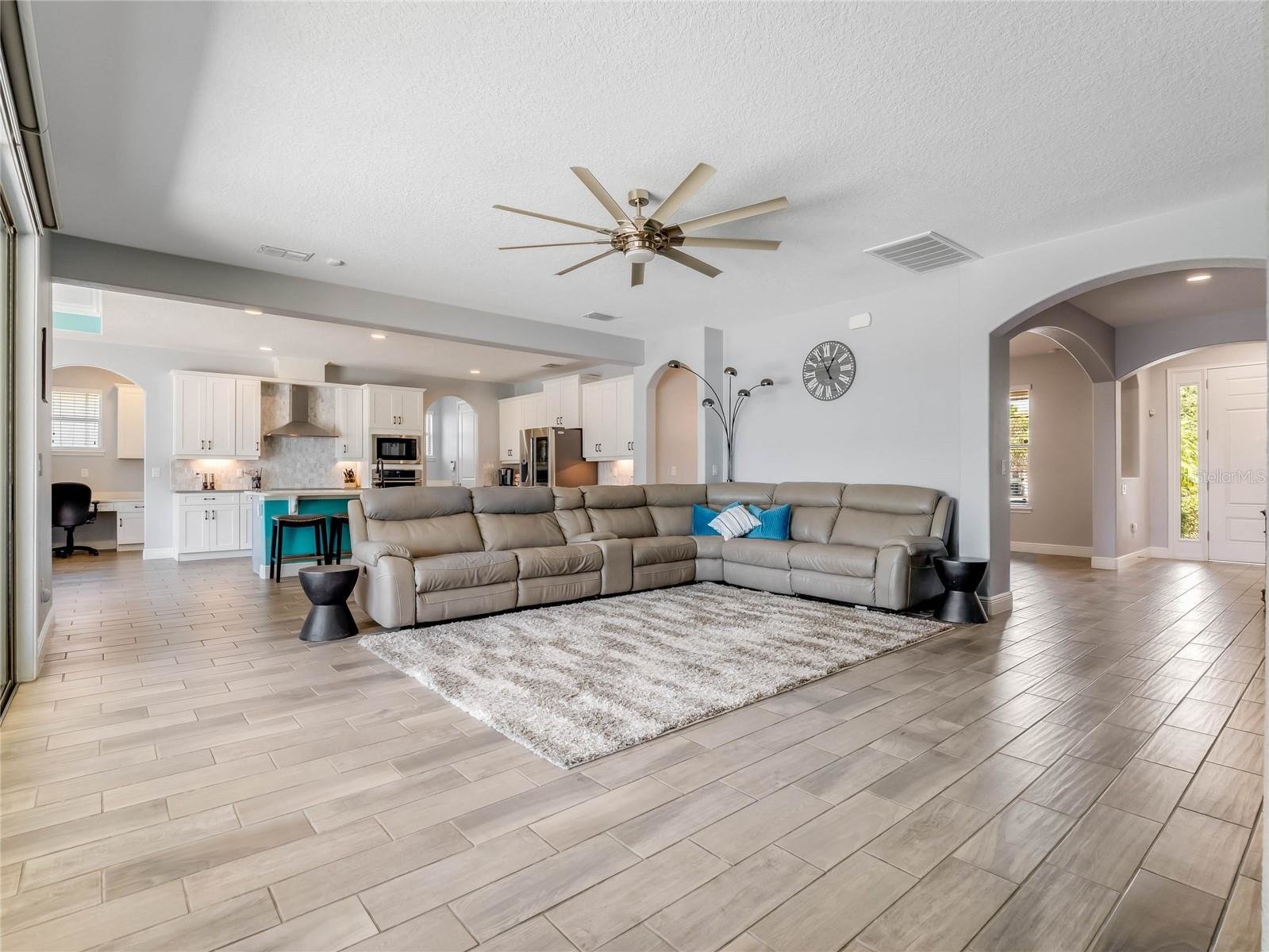 Living room with large beige sectional and wood floors